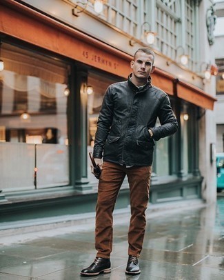 Comment porter un jean marron: Porte une veste style militaire noire et un jean marron pour une tenue confortable aussi composée avec goût. Cette tenue se complète parfaitement avec une paire de bottines chukka en cuir noires.