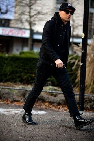 Comment porter des bottes habillées en cuir noires: Pour une tenue de tous les jours pleine de caractère et de personnalité associe une veste universitaire noire avec un jean noir. Une paire de bottes habillées en cuir noires ajoutera de l'élégance à un look simple.