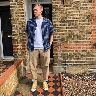Comment porter un t-shirt à col rond blanc avec des baskets basses en toile moutarde