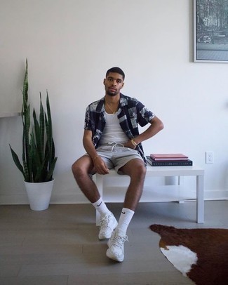 Comment porter un débardeur blanc avec des chaussures de sport blanches et noires en été